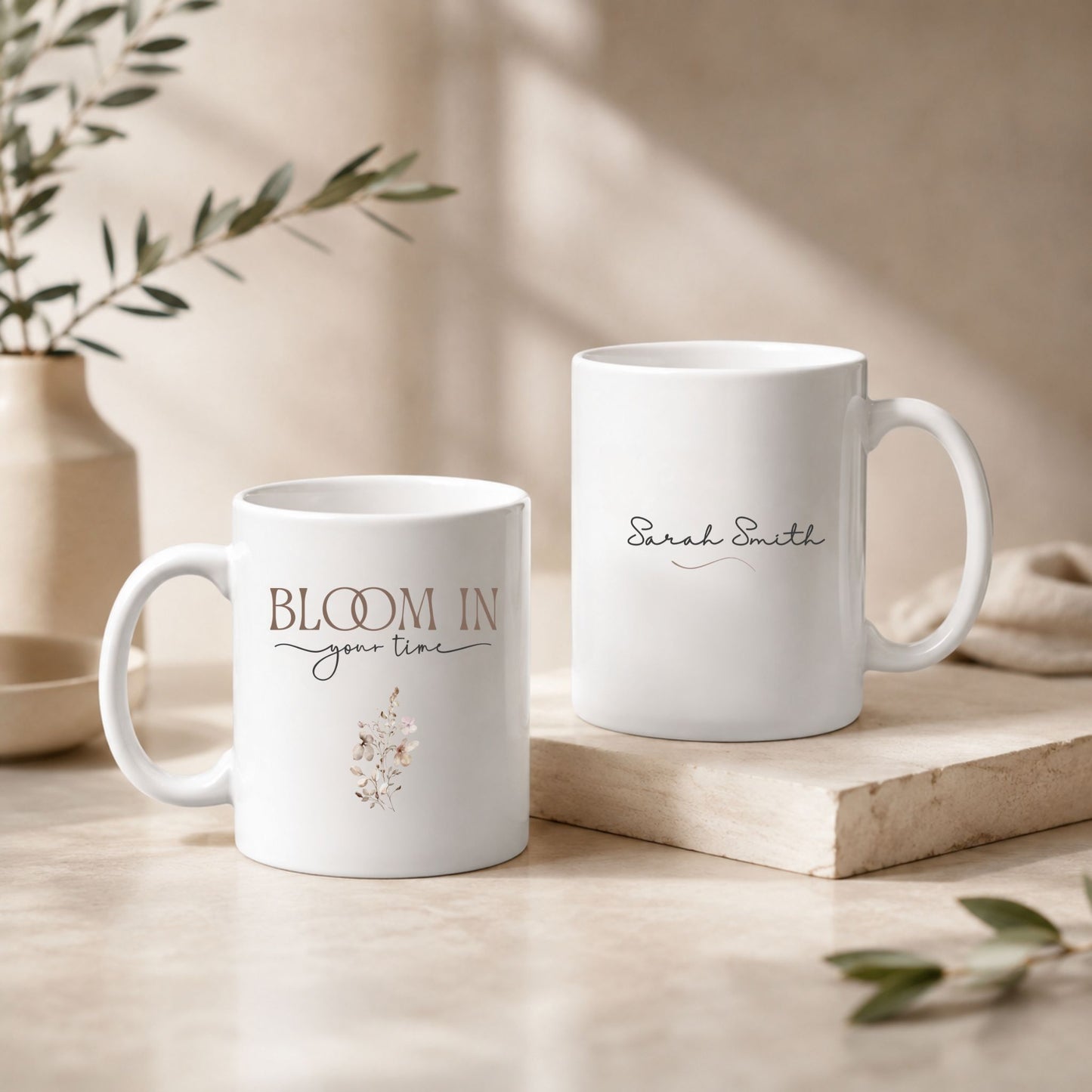 Bloom in Your Time floral mug paired with a personalized name mug in a minimalist luxury lifestyle setting with warm beige decor and natural daylight.
