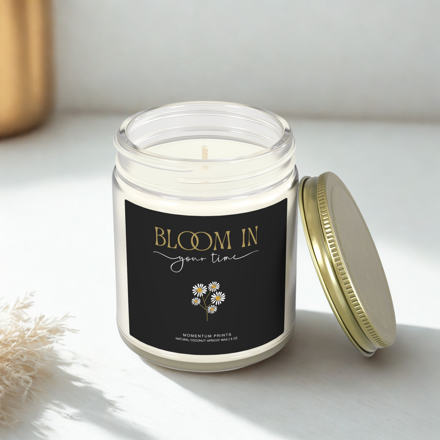Motivational “Bloom in Your Time” soy candle with gold lid on bright white surface — minimal cozy decor by Momentum Prints.