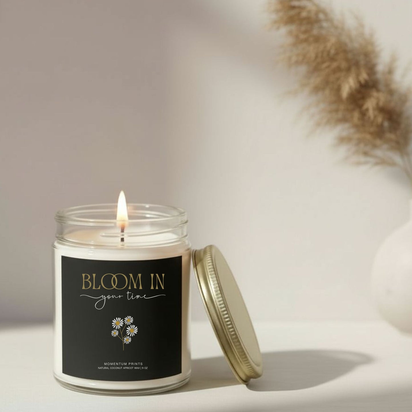 Bloom in Your Time” inspirational candle with soft flame on neutral beige background — elegant floral design by Momentum Prints.