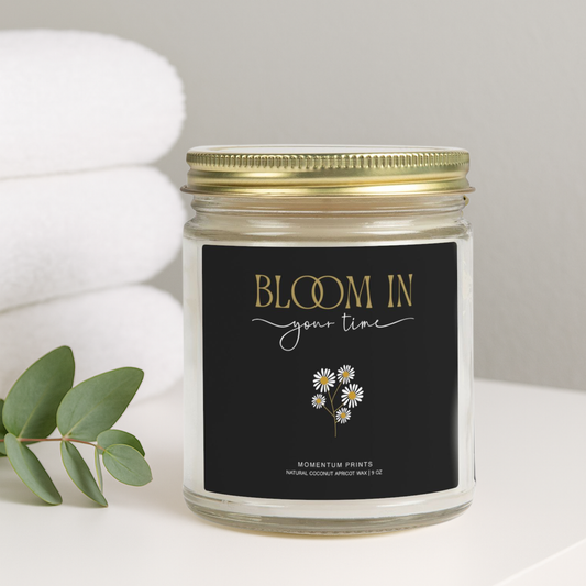 Bloom in Your Time” daisy-design soy candle by Momentum Prints on spa towel background — cozy minimalist lifestyle photo