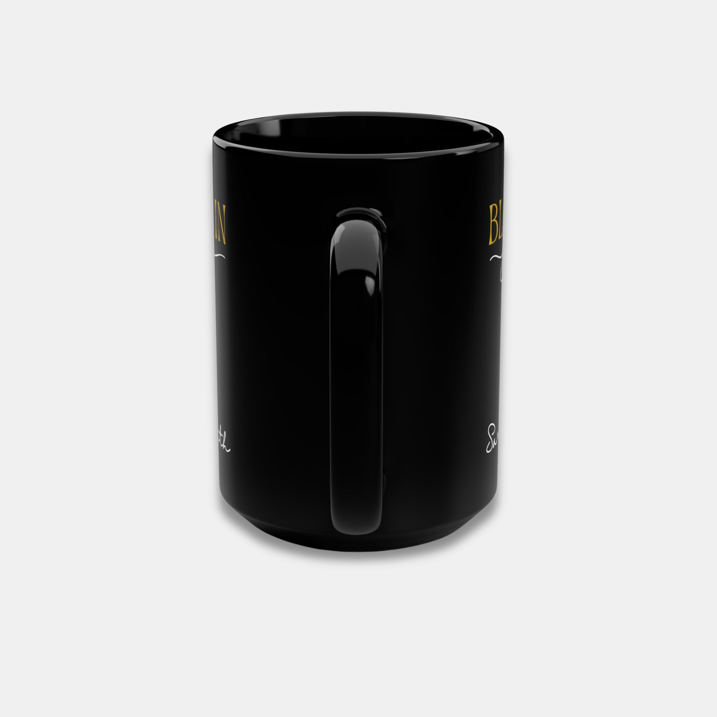 Black personalized mug with partial “Bloom in Your Time” design and handle-centered side view on a light background.