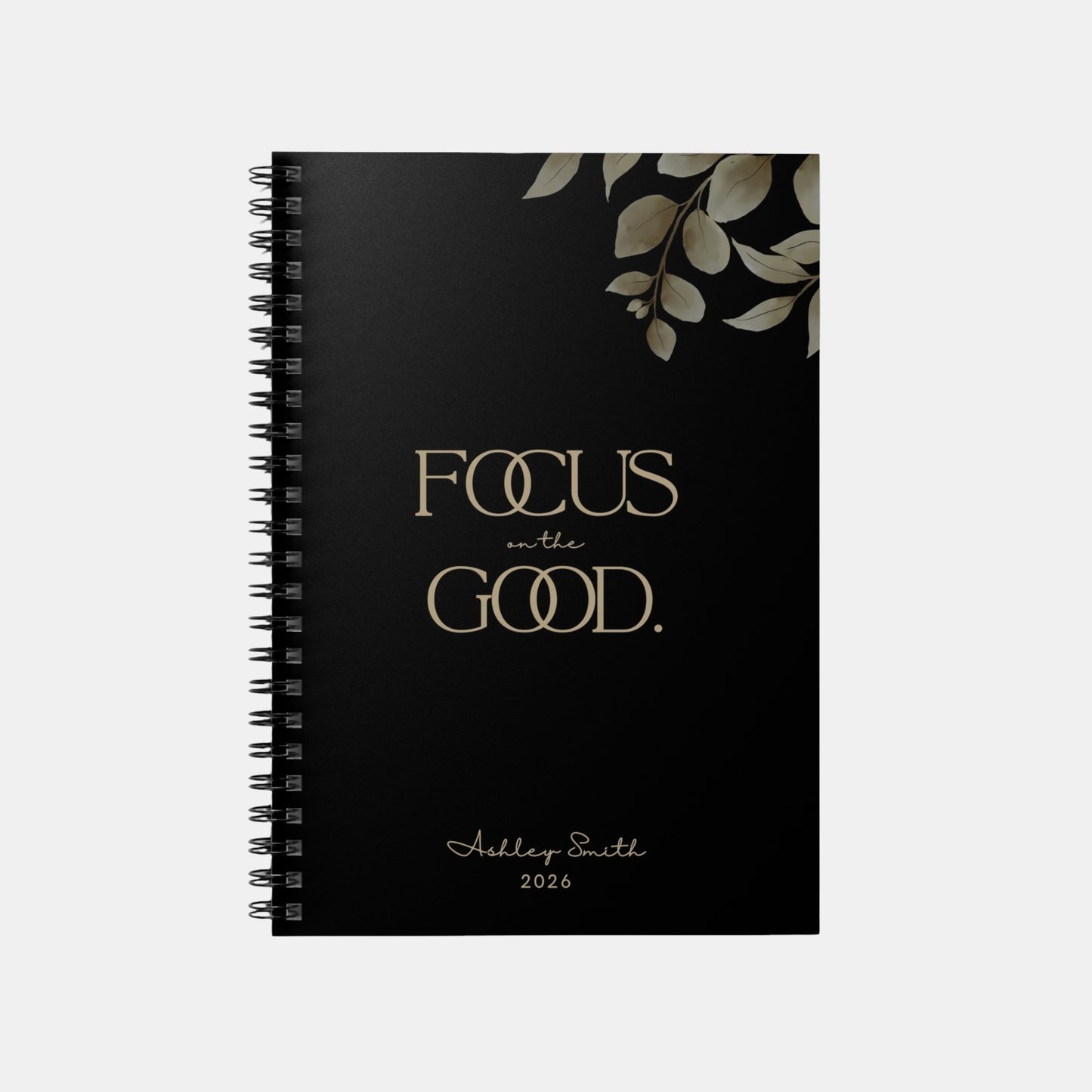 Personalized “Focus on the Good” spiral notebook in midnight black with gold typography and minimalist botanical design.
