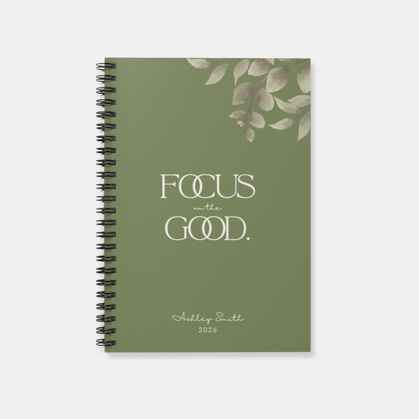 Front view of olive green “Focus on the Good” spiral notebook with personalized name option, minimalist aesthetic.