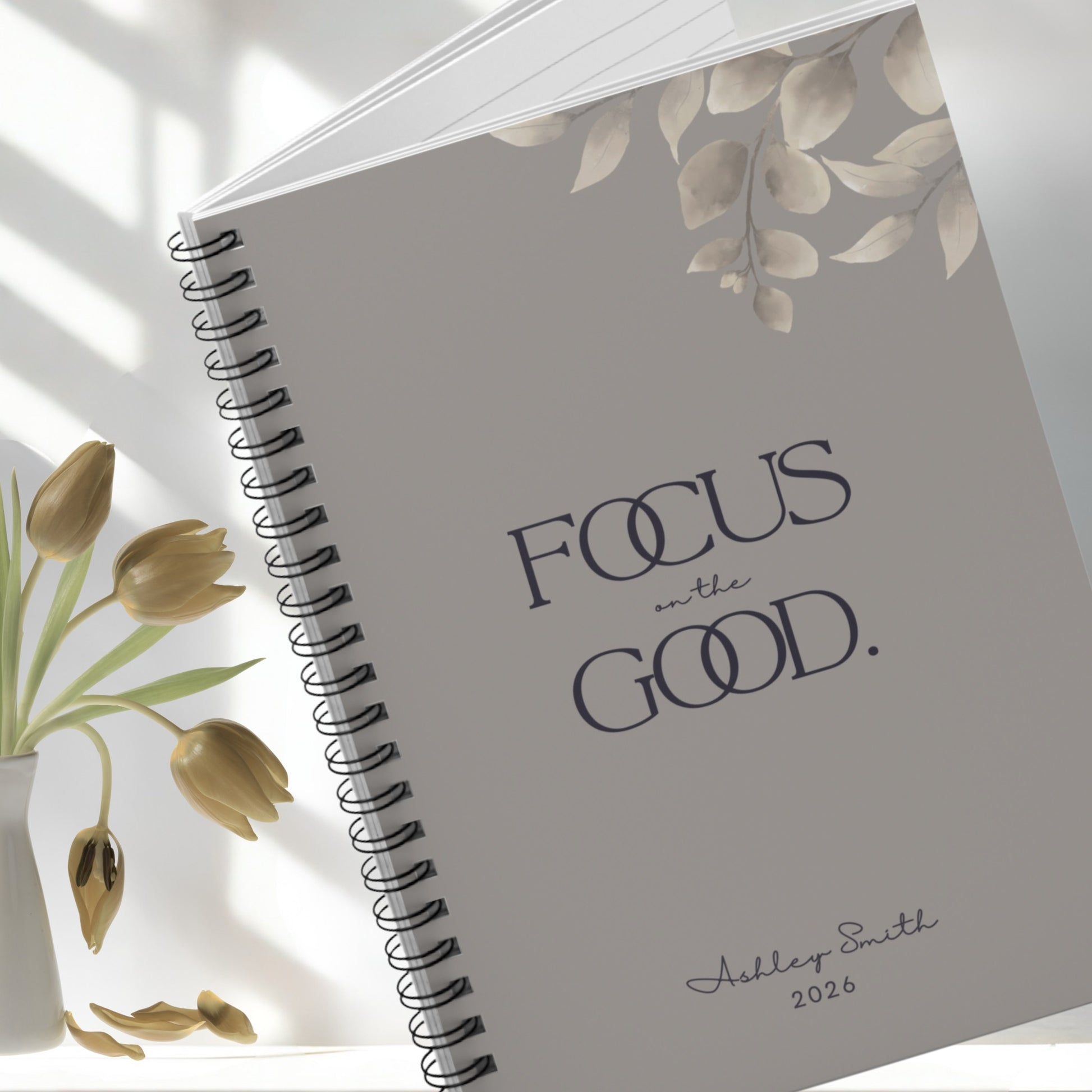 Focus on the Good warm gray spiral notebook cover detail with minimalist typography and soft neutral floral accents.