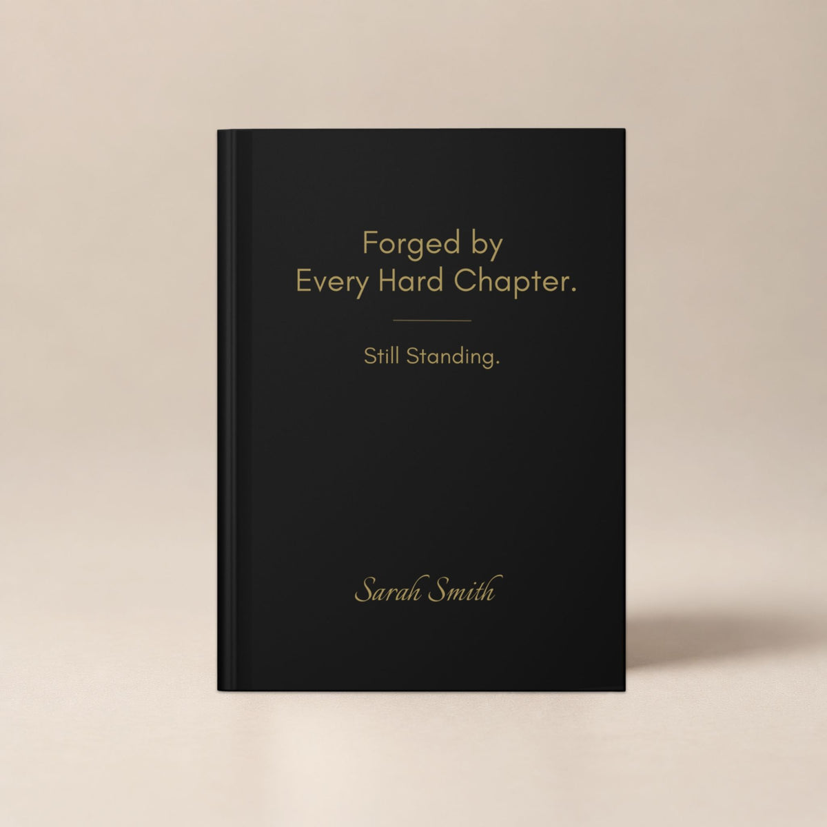Front view of a black personalized hardcover journal with gold typography against a soft neutral background.