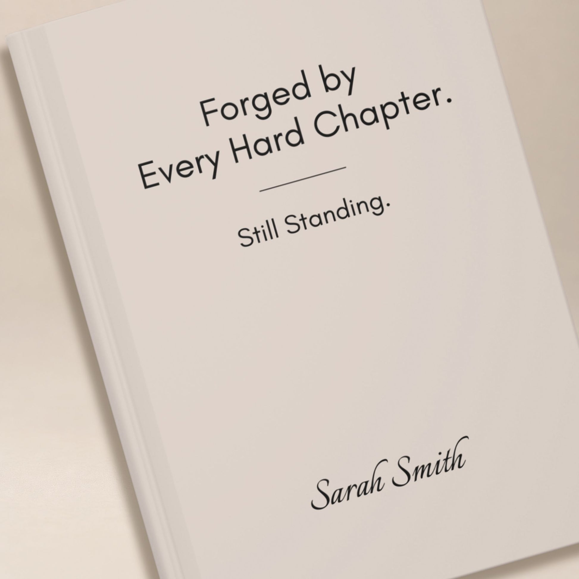 Close up detail of a personalized ivory hardcover journal cover, showing black lettering and a name in script typography by Momentum Prints.