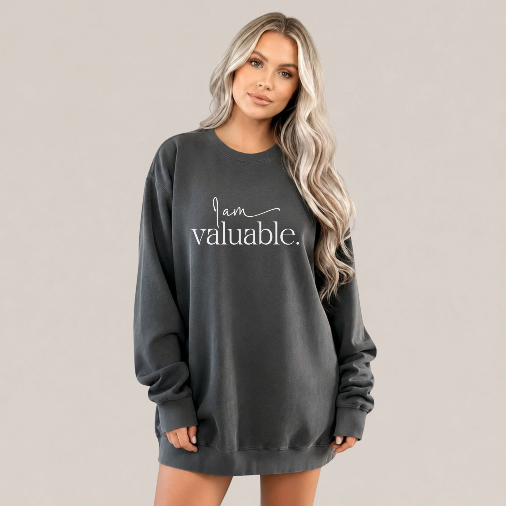 Woman wearing an oversized pepper sweatshirt with a minimalist design in a neutral studio setting, cozy premium apparel by Momentum Prints.