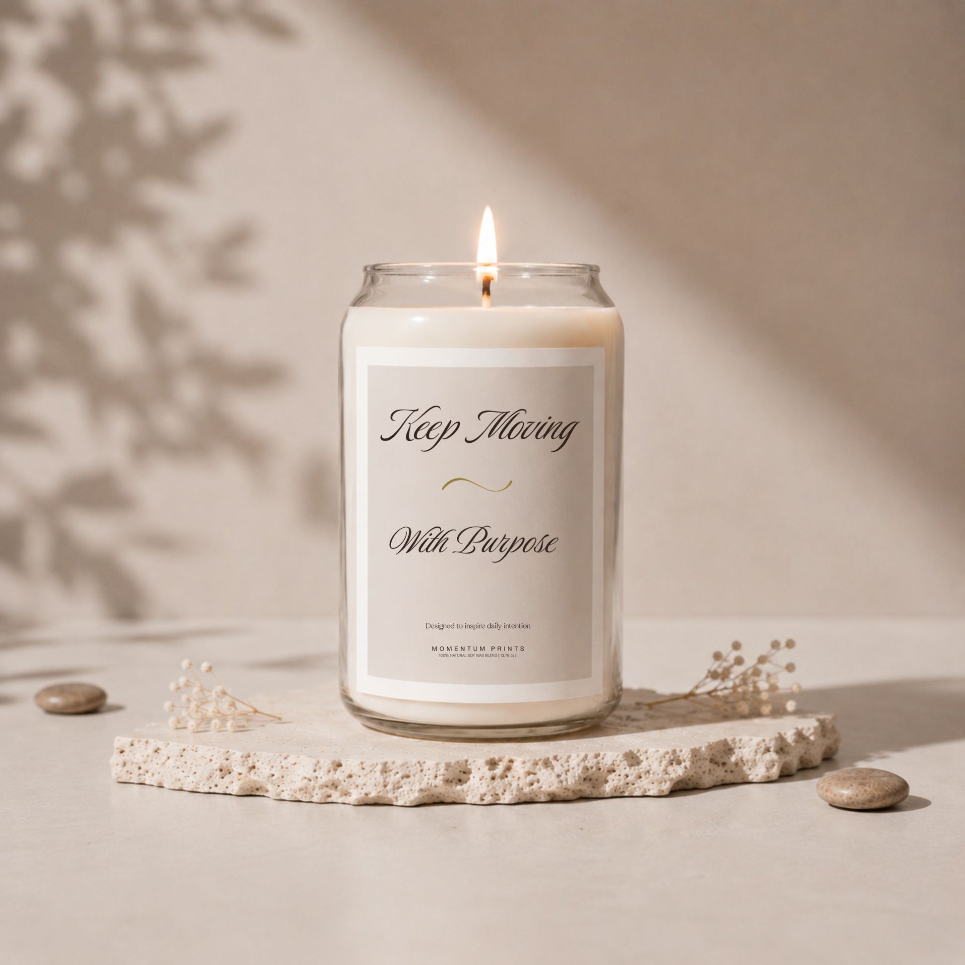 Minimalist luxury candle with “Keep Moving With Purpose” label on textured stone tray, lit soy candle in clear glass jar with soft beige aesthetic and warm editorial lighting