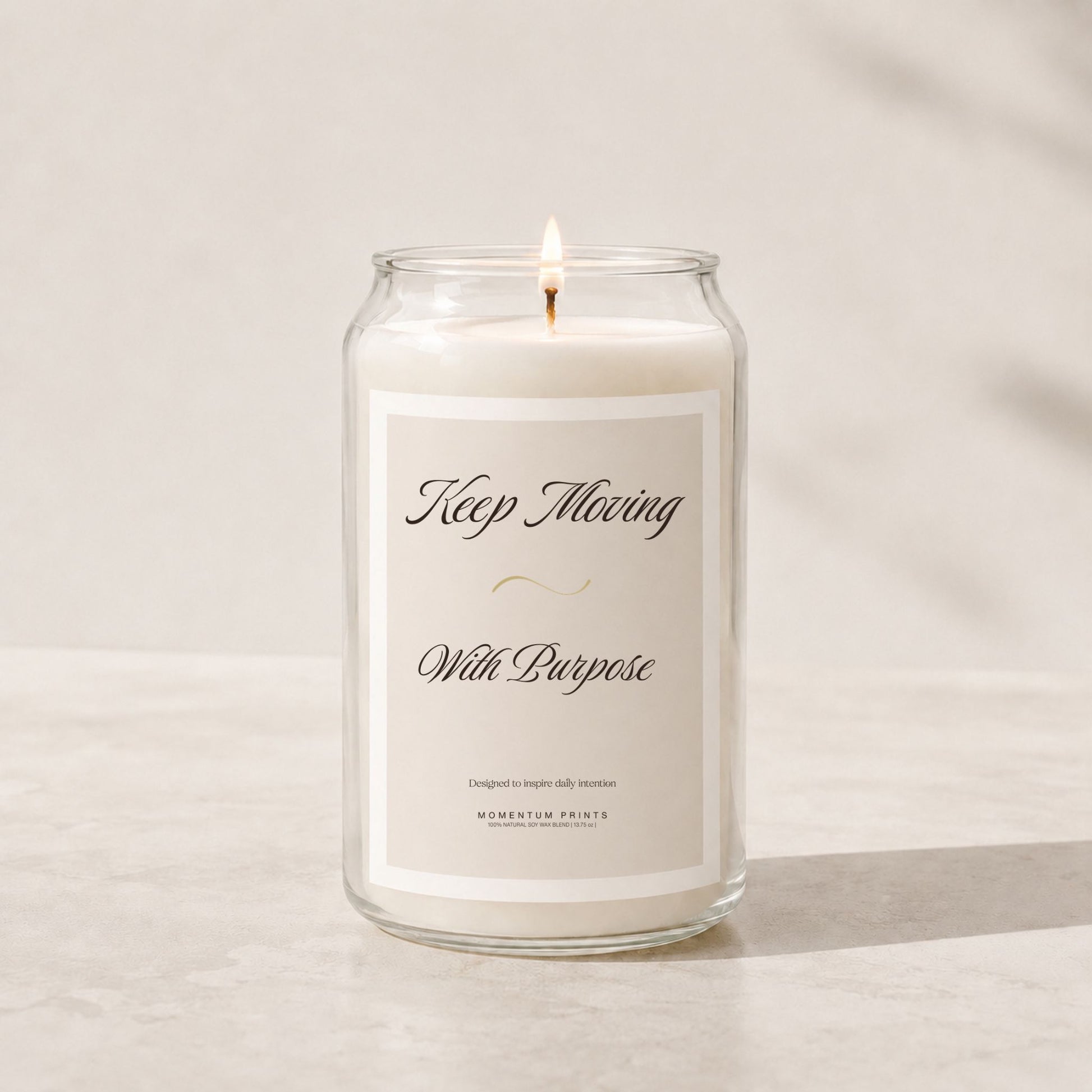 Minimalist luxury soy candle in a clear glass jar with a soft beige label reading “Keep Moving With Purpose,” styled on a light stone surface with warm natural lighting and a clean neutral background.