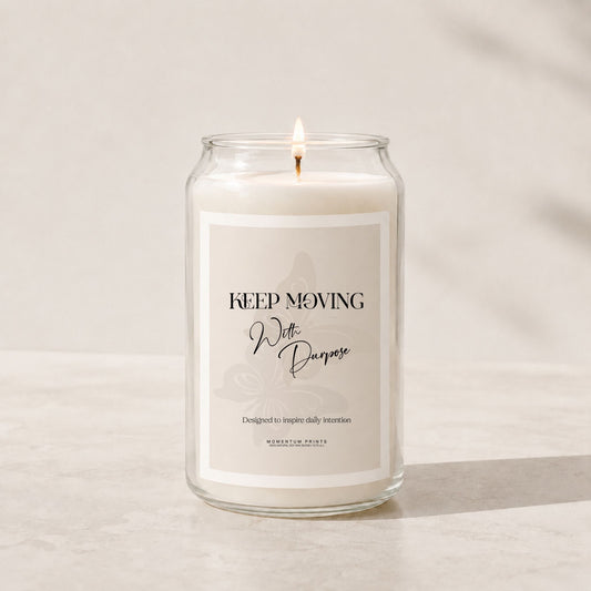 Minimalist luxury soy candle in a clear glass jar with a soft beige label reading “Keep Moving With Purpose,” styled on a light stone surface with warm natural lighting and a clean neutral background.