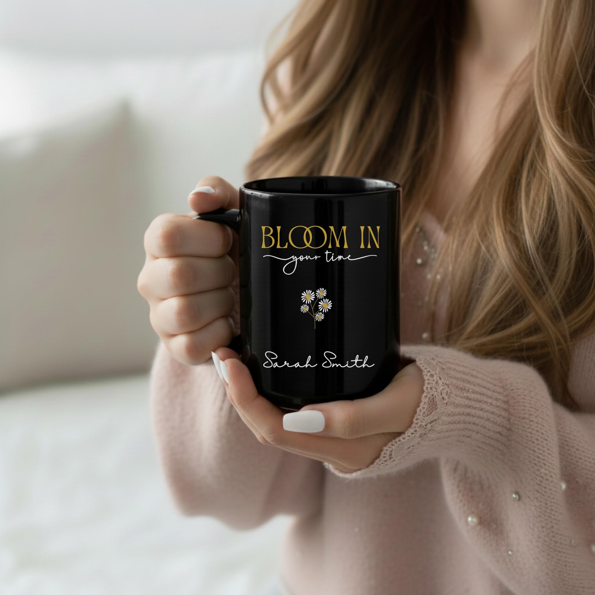 Personalized black ceramic mug held in hand, featuring the “Bloom in Your Time” design with custom name detail, photographed in a soft cozy lifestyle scene.
