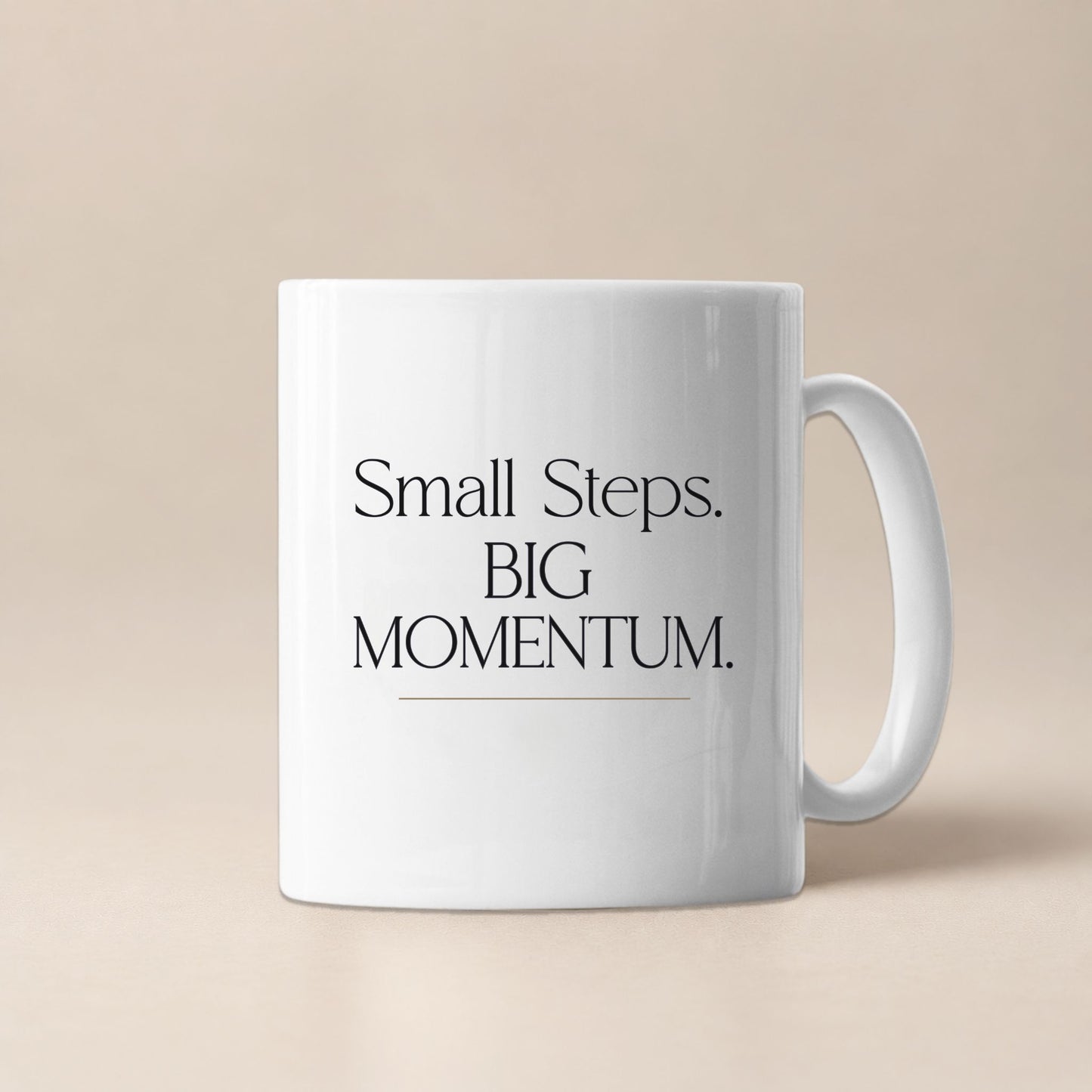 White ceramic mug displaying the Small Steps. BIG MOMENTUM. design against a soft beige background.