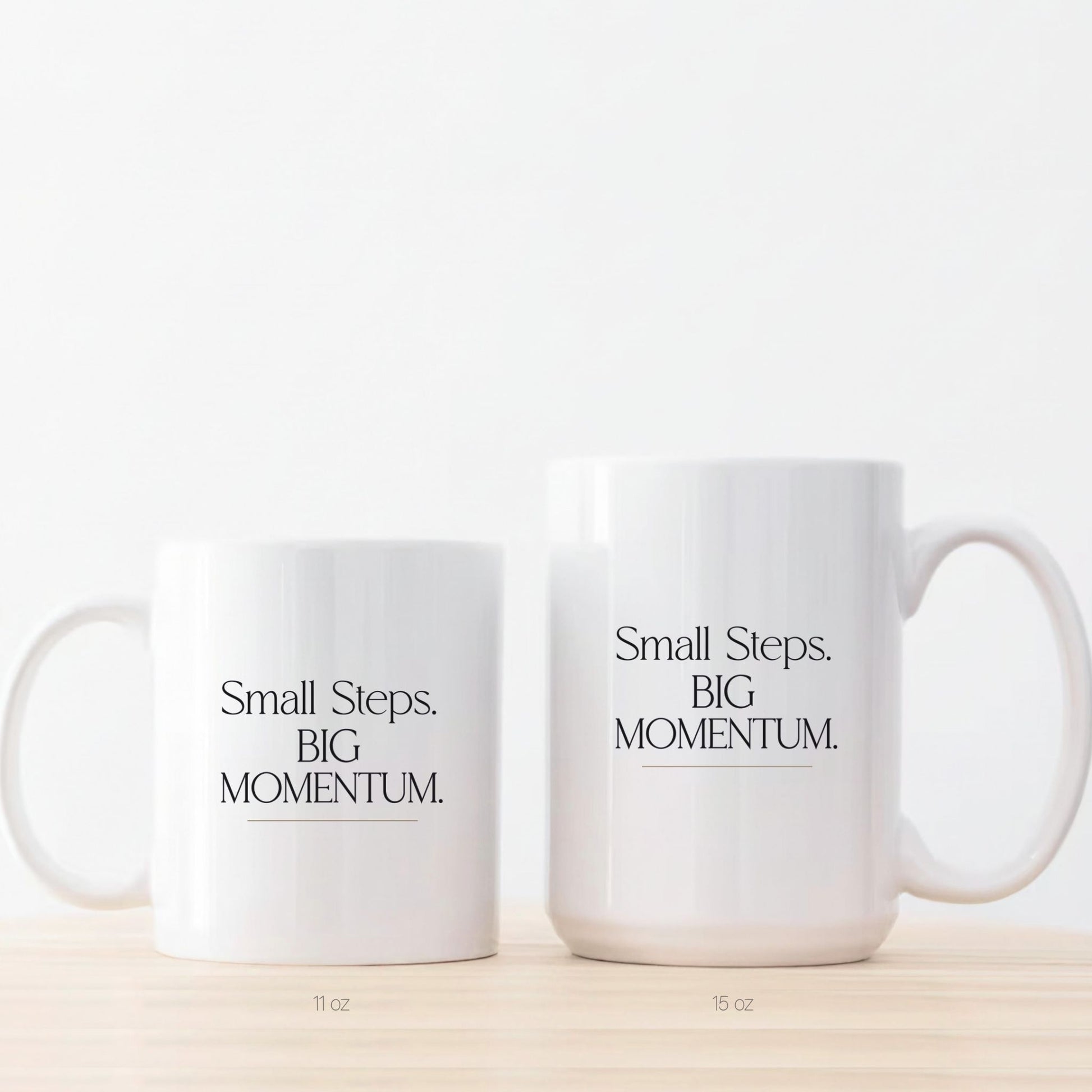 Two white ceramic mugs displayed side by side showing the difference between the 11 oz and 15 oz sizes. Momentum Prints.