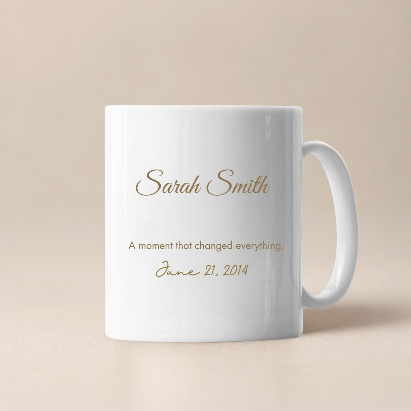 Personalized white ceramic mug with custom name, meaningful date and sentimental message in gold lettering, minimalist beige background, elegant keepsake gift for special occasions.