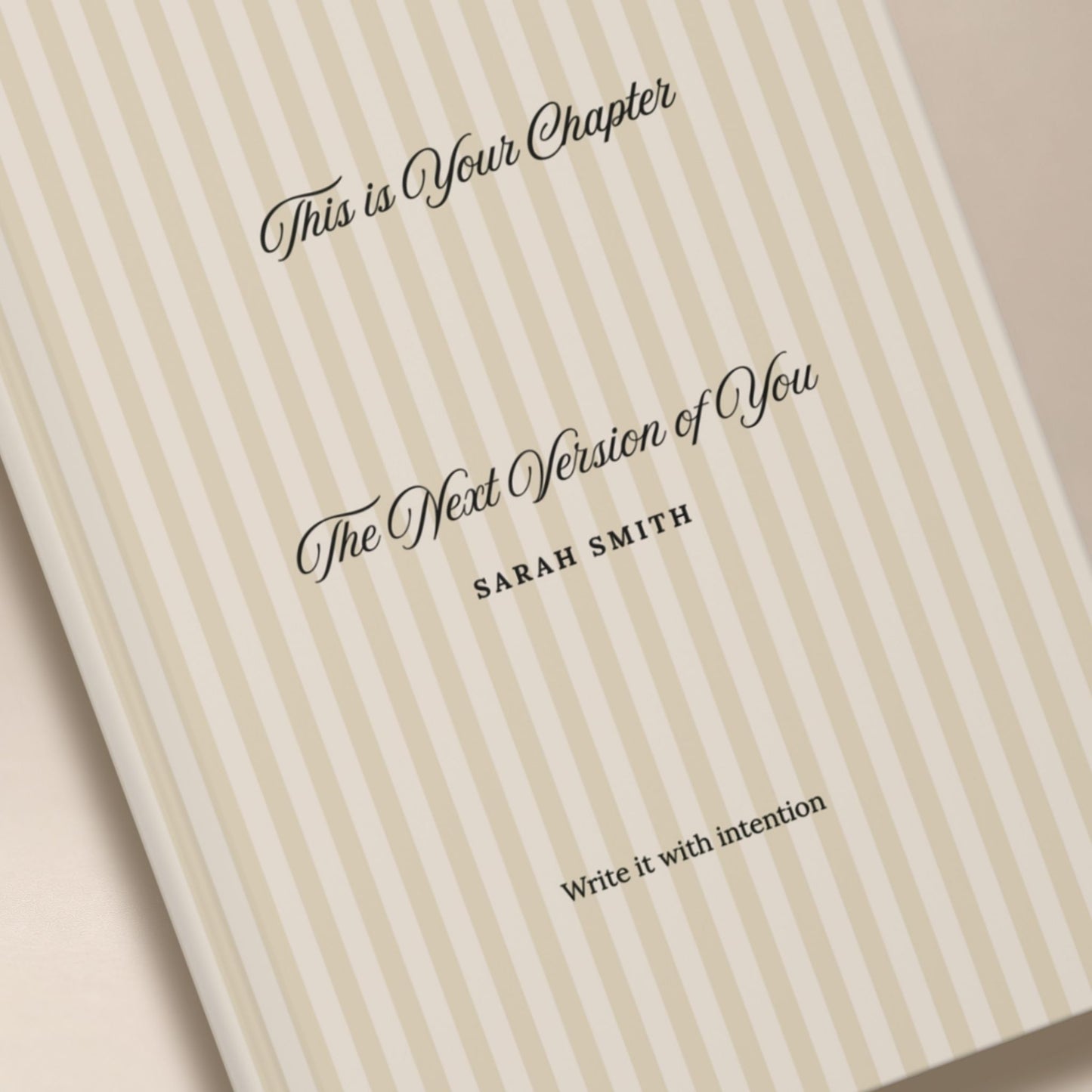 Close-up of a premium personalized hardcover journal with a beige striped cover and black script lettering, styled in a luxury editorial detail shot by Momentum Prints.