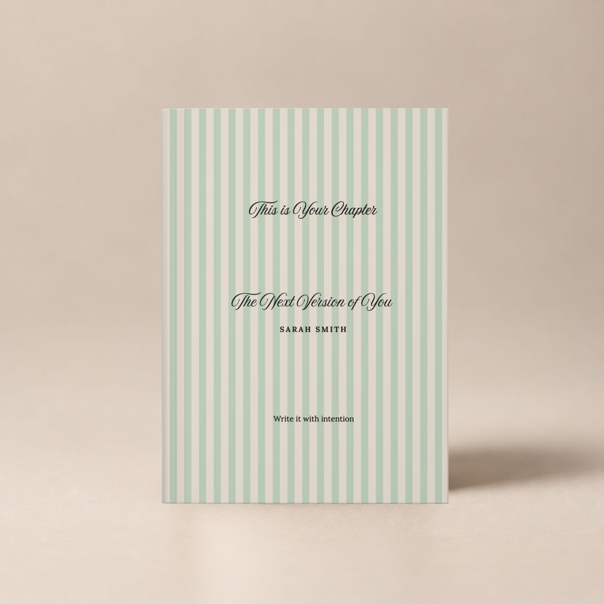 Front view of a premium personalized hardcover journal with a sage green striped cover and black script lettering, shown standing upright on a soft beige background by Momentum Prints.
